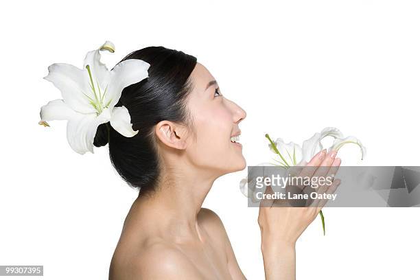 beauty shot of a young woman with lily flowers - lili gentle fotografías e imágenes de stock