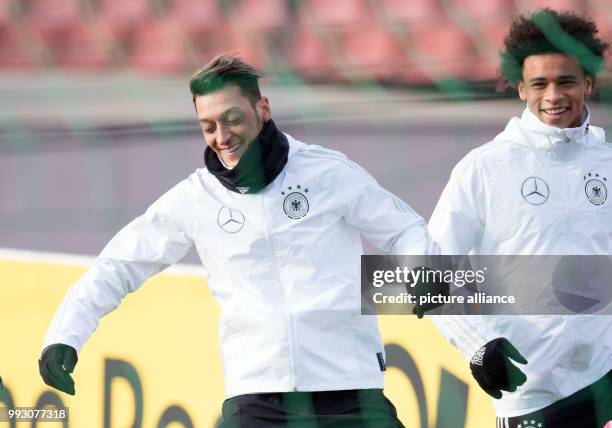 Germany's Mesut Ozil and Leroy Sané laughing during the German national soccer squad's training at the Friedrich Ludwig Jahn sports park in Berlin,...