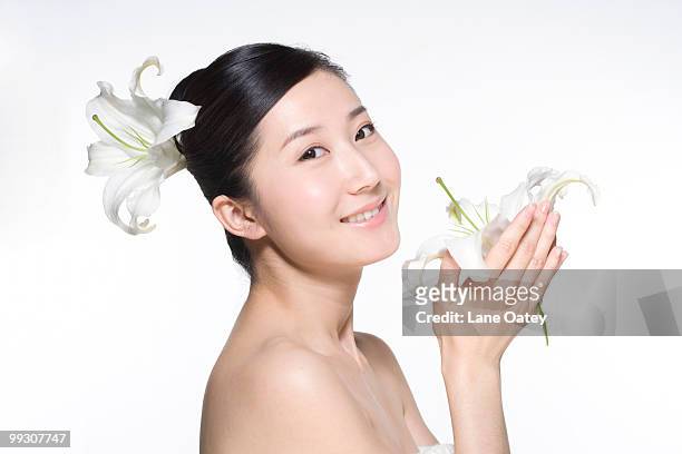 beauty shot of a young woman with a lily flower - lili gentle fotografías e imágenes de stock