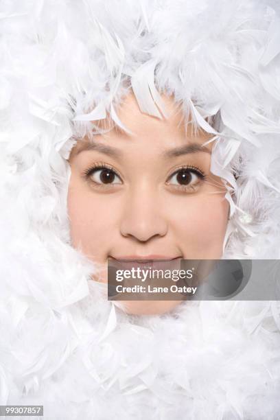 feathers surrounding the face of young woman - boa skin stock pictures, royalty-free photos & images