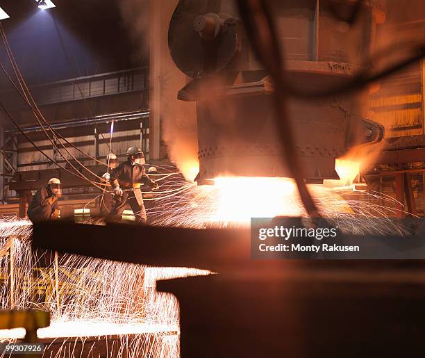 workers pouring molten steel in plant - steelmaking stock pictures, royalty-free photos & images