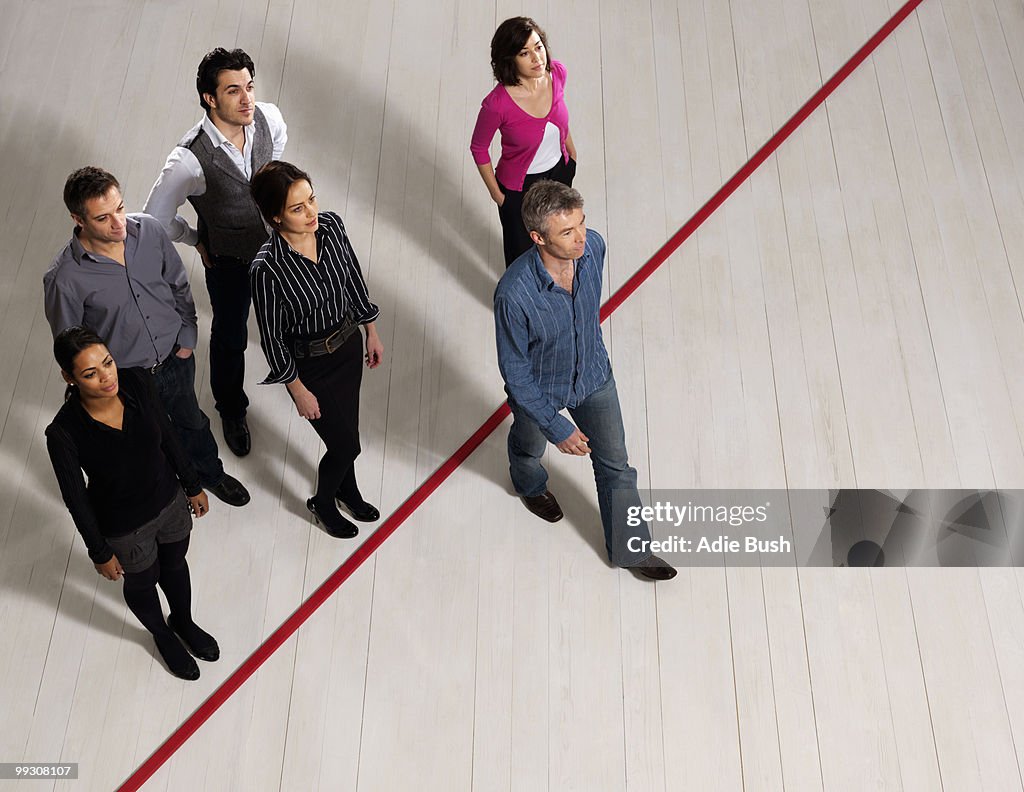 Business men and women crossing red line