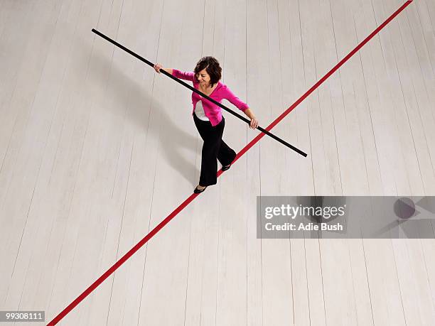 woman balancing on thin red line - tightrope walker stock pictures, royalty-free photos & images