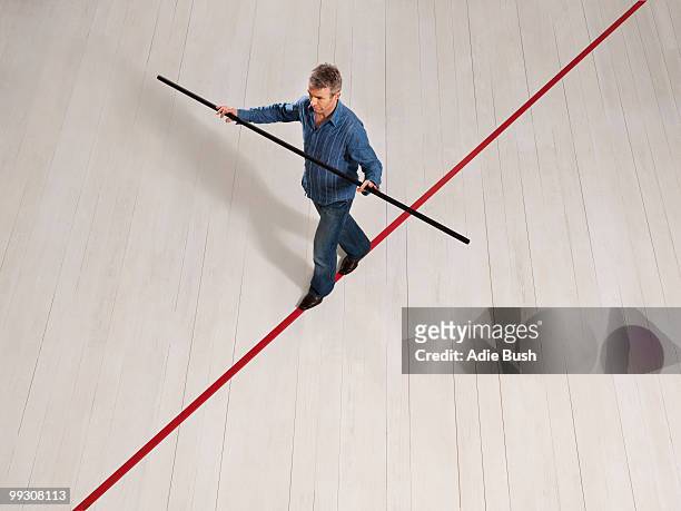 man balancing on thin red line with pole - pole positie fotografías e imágenes de stock
