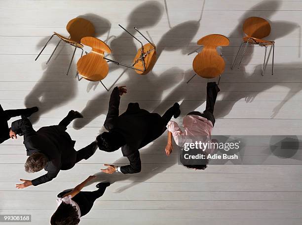 business people knocking over chairs - deadline contenders stock pictures, royalty-free photos & images