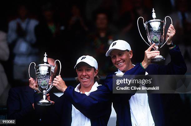 Lisa Raymond of USA and Rennae Stubbs of Australia lift their trophies after defeating Kim Clijsters of Belgium and Ai Sugiyama of USA in the Women's...