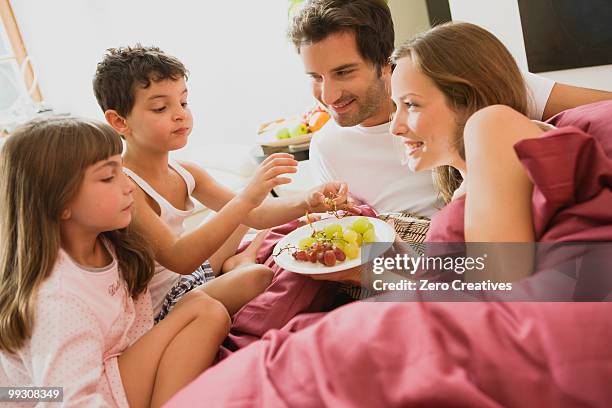 family having breakfast in bed - dietramszell stock pictures, royalty-free photos & images