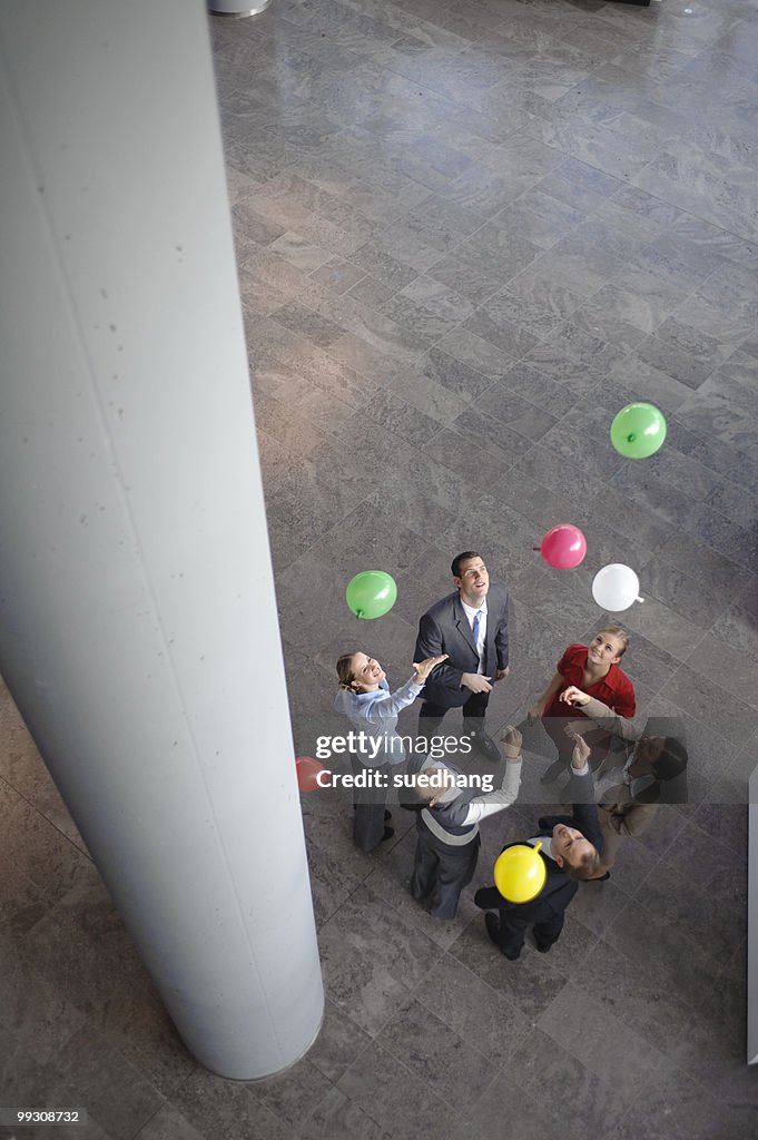 Business team sets colored balloons free