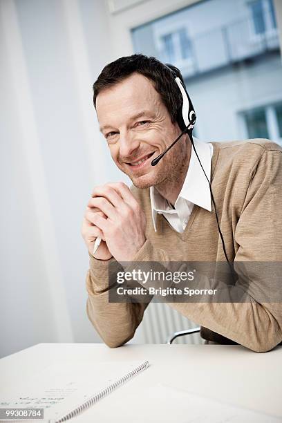 male call center agent smiling - brigitte sporrer stock pictures, royalty-free photos & images