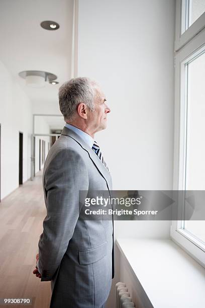 businessman looking at window - three quarter length fotografías e imágenes de stock