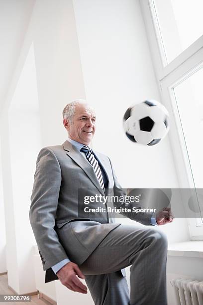 businessman playing soccer - brigitte sporrer stock pictures, royalty-free photos & images