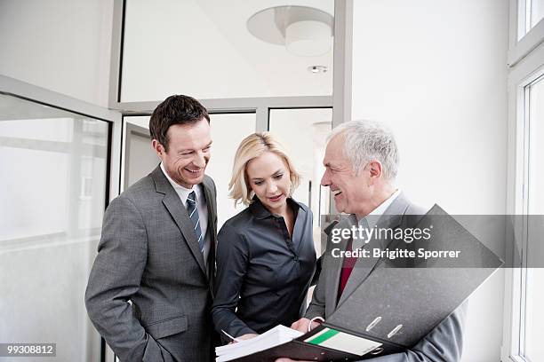 businesspeople looking at folder - brigitte sporrer stock pictures, royalty-free photos & images