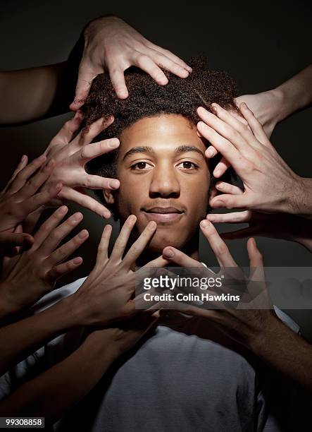 black male surrounded by hands - colin hawkins stock pictures, royalty-free photos & images