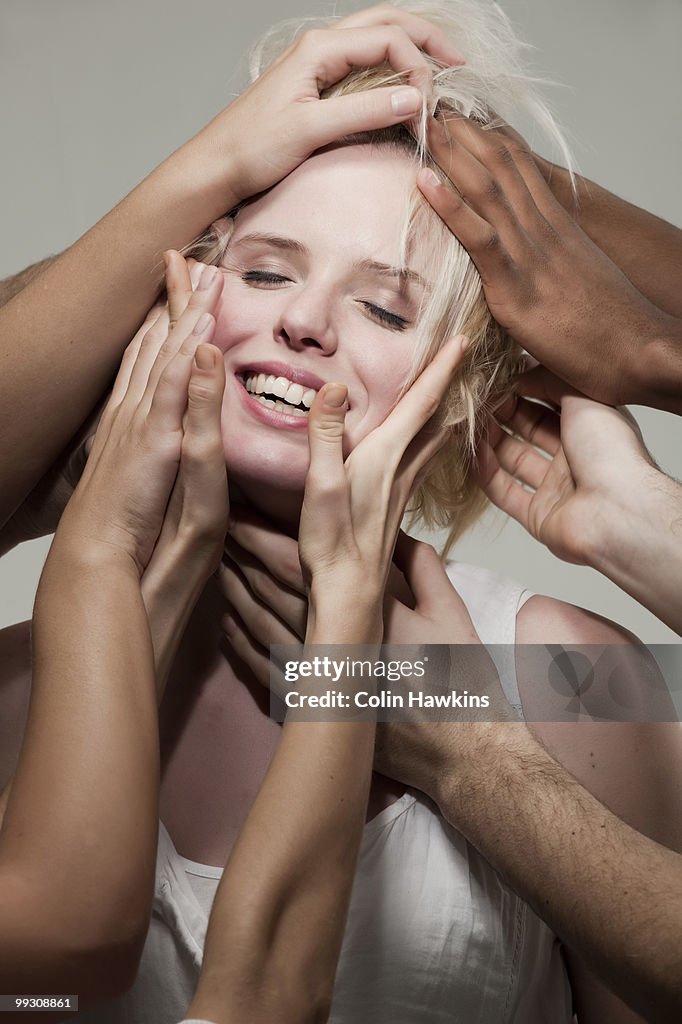 Woman being touched by many hands