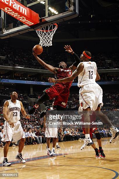 Dwyane Wade of the Miami Heat shoots a layup against Tyrus Thomas of the Charlotte Bobcats during the game at Time Warner Cable Arena on March 9,...