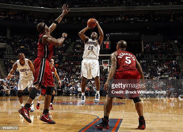 Raymond Felton of the Charlotte Bobcats shoots a jump shot against Jermaine O'Neal and Quentin Richardson of the Miami Heat during the game at Time...