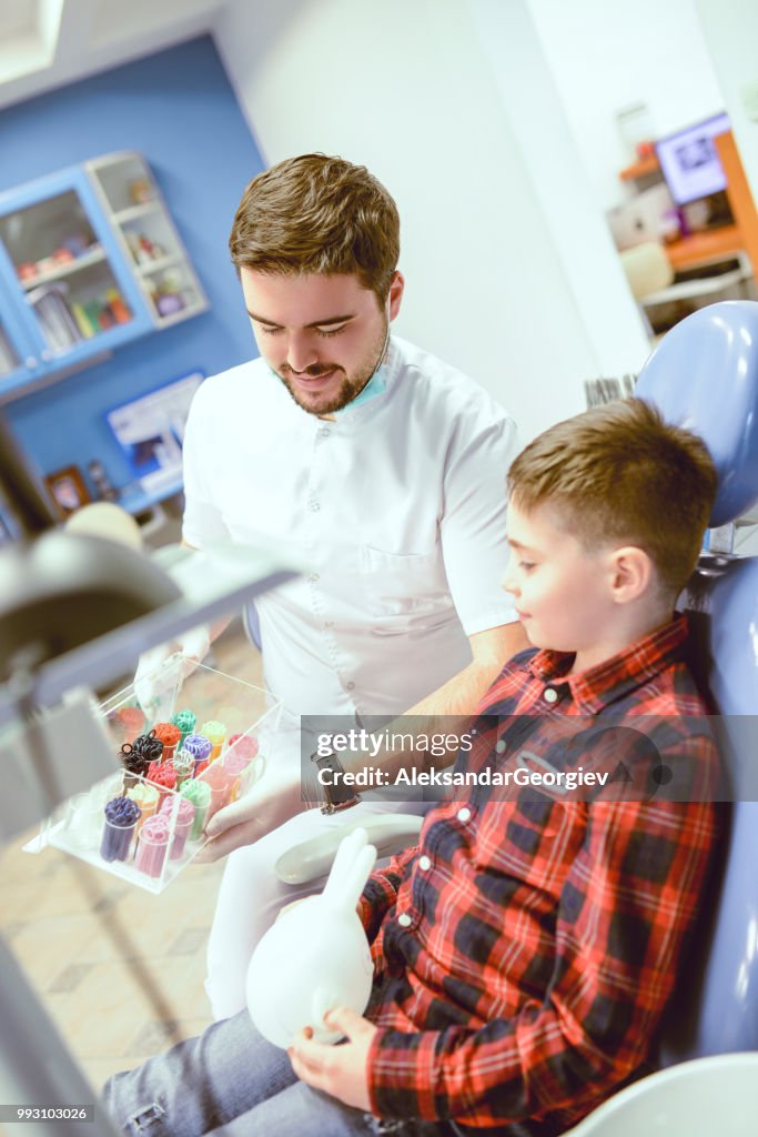 Dentist Helping Boy To Choose Braces Color