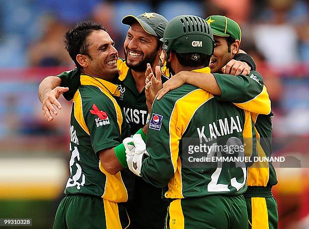 Pakistani bowler Abdur Rehman celebrates with Kamran Akmal and captain Shahid Afridi after taking the wicket of Australian batsman Brad Haddin during...