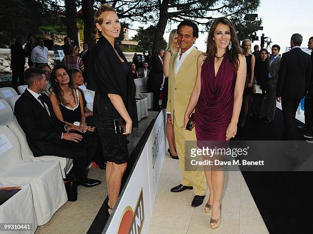 Actress Liz Hurley and husband Arun Nayar talk with Charlene Wittstock, girlfriend of Prince Albert II of Monaco as they attend the Amber Fashion...
