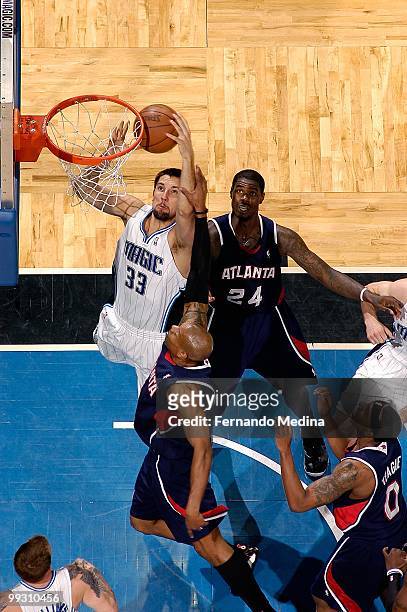 Ryan Anderson of the Orlando Magic goes up against Maurice Evans and Marvin Williams of the Atlanta Hawks in Game One of the Eastern Conference...
