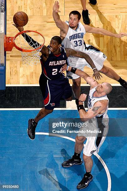 Marvin Williams of the Atlanta Hawks lays the ball up over Marcin Gortat and Ryan Anderson of the Orlando Magic in Game One of the Eastern Conference...