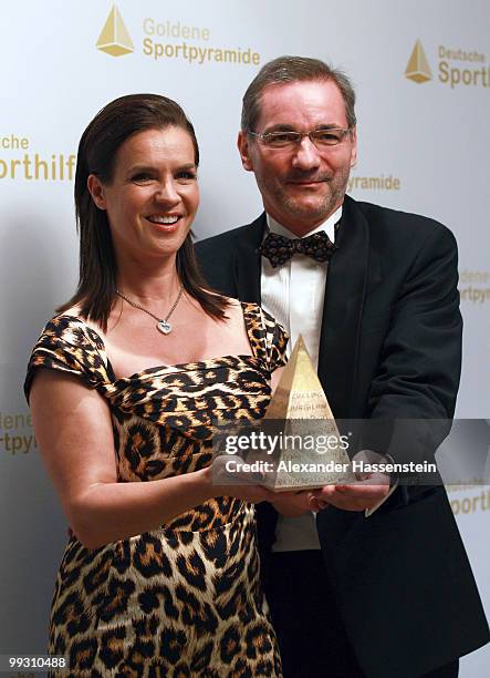 Katarina Witt poses with Brandenburg's Minister President Matthias Platzeck and the Goldene Sportpyramide Award at the Adlon Hotel on May 14, 2010 in...