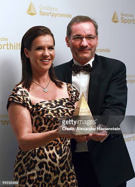 Katarina Witt poses with Brandenburg's Minister President Matthias Platzeck and the Goldene Sportpyramide Award at the Adlon Hotel on May 14, 2010 in...