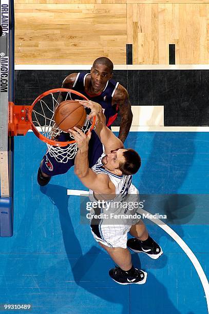 Ryan Anderson of the Orlando Magic slam dunks over Jamal Crawford of the Atlanta Hawks in Game One of the Eastern Conference Semifinals during the...