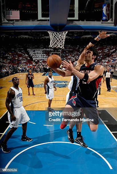 Zaza Pachulia of the Atlanta Hawks lays the ball up past Marcin Gortat of the Orlando Magic in Game One of the Eastern Conference Semifinals during...