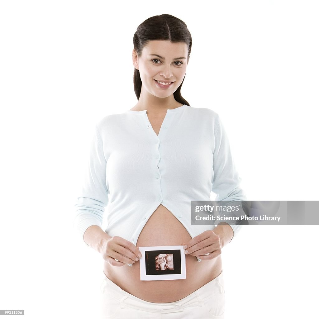 Pregnant woman holding her baby scan