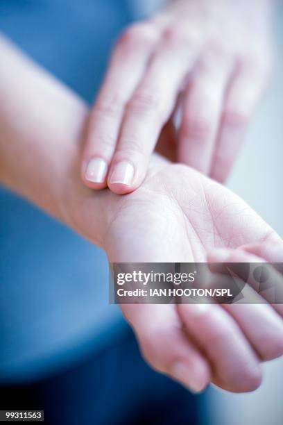 Checking Pulse On Wrist Fotografías e imágenes de stock - Getty Images