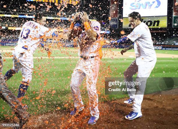 Jose Bautista of the New York Mets is hit with a gatorade bath aby Asdrubal Cabrera and Wilmer Flores after hitting a walkoff Grand Slam against the...