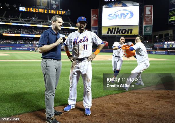 Jose Bautista of the New York Mets is hit with a gatorade bath aby Asdrubal Cabrera and Wilmer Flores after hitting a walkoff Grand Slam against the...