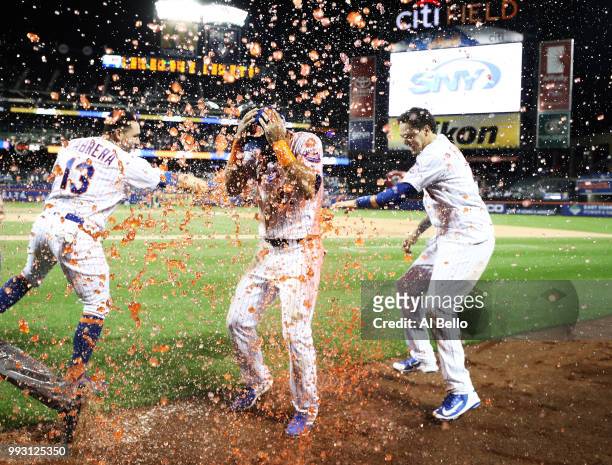 Jose Bautista of the New York Mets is hit with a gatorade bath aby Asdrubal Cabrera and Wilmer Flores after hitting a walkoff Grand Slam against the...