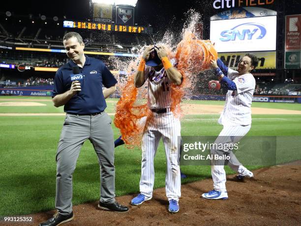 Jose Bautista of the New York Mets is hit with a gatorade bath aby Asdrubal Cabrera and Wilmer Flores after hitting a walkoff Grand Slam against the...