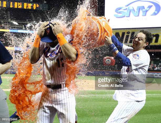 Jose Bautista of the New York Mets is hit with a gatorade bath by Asdrubal Cabrera and Wilmer Flores after hitting a walkoff Grand Slam against the...