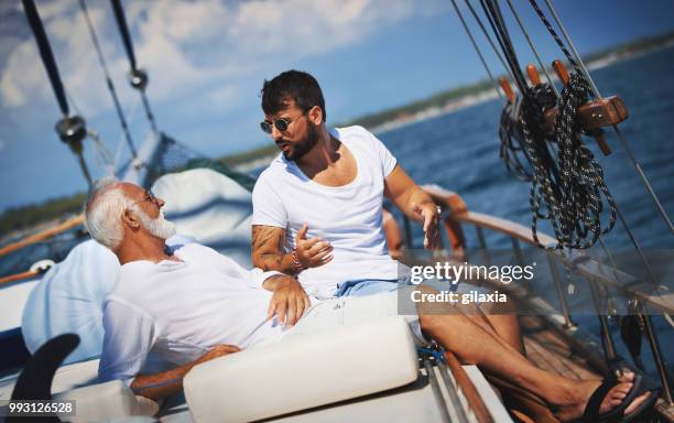 father and son sailing. - gilaxia stock pictures, royalty-free photos & images