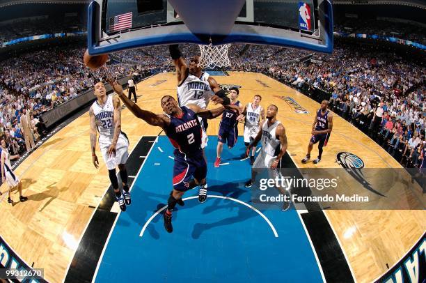 Joe Johnson of the Atlanta Hawks loses control of the ball under pressure from Dwight Howard of the Orlando Magic in Game One of the Eastern...