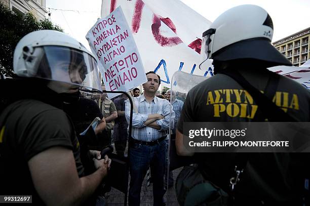 Demonstrator holds a banner reading "United Cyprus, Armenian and Kurdi front" in front of Greek police officers in central Athens, during a joint...