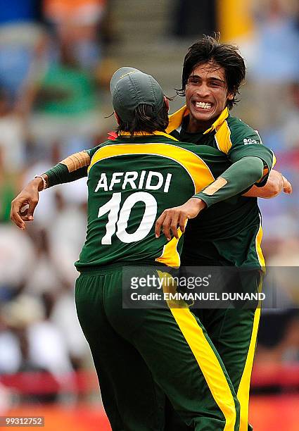 Pakistani bowler Mohammad Aamer celebrates with captain Shahid Afridi after taking the wicket of Australian batsman Cameron White during the ICC...