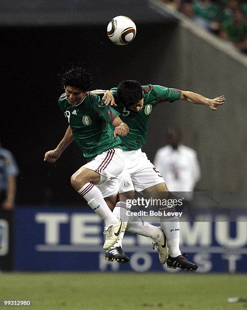 Jonny Magallon and Ricardo Osorio of Mexico go up for a header against Angola at Reliant Stadium on May 13, 2010 in Houston, Texas.