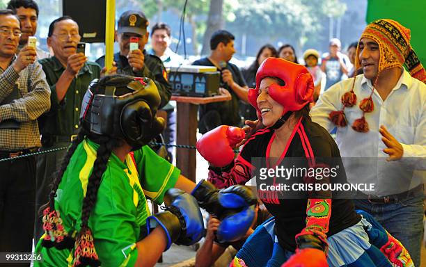 Onlookers record on their cellular telephones two Andean peasant women , representing Peru and Bolivia, measure themselves in a boxing ring on May 13...