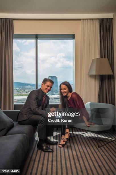 man and woman couple in a hotel using tech devices - auf der suche nach liebe stock-fotos und bilder