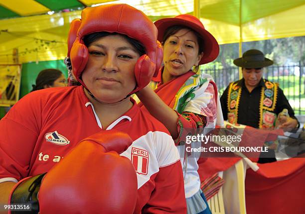 Peruvian Lidia Chavez, an Andean peasant woman , gets ready for a boxing match wearing a t-shirt with the colors of her national flag, before...