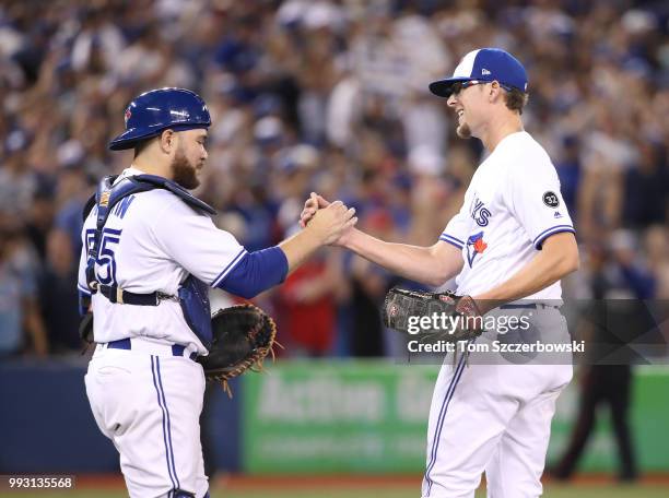 Tyler Clippard of the Toronto Blue Jays celebrates their victory with Russell Martin during MLB game action against the New York Yankees at Rogers...