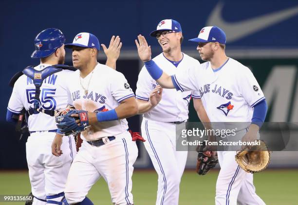 Tyler Clippard of the Toronto Blue Jays celebrates their victory with Justin Smoak and Yangervis Solarte and Russell Martin during MLB game action...
