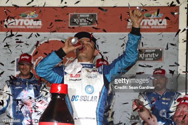 Kyle Larson, driver of the DC Solar Chevrolet, celebrates in Victory Lane after winning the NASCAR Xfinity Series Coca-Cola Firecracker 250 at...
