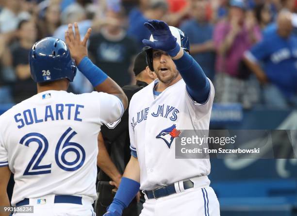 Justin Smoak of the Toronto Blue Jays is congratulated by Yangervis Solarte after hitting a three-run home run in the second inning during MLB game...