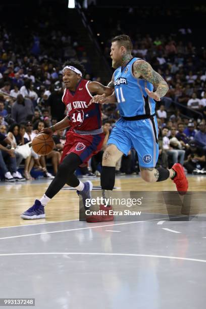 David Hawkins of Tri State drives with the ball against Chris Andersen of Power during week three of the BIG3 three on three basketball league game...