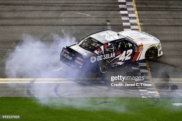 Kyle Larson, driver of the DC Solar Chevrolet, celebrates with a burnout after winning the NASCAR Xfinity Series Coca-Cola Firecracker 250 at Daytona...